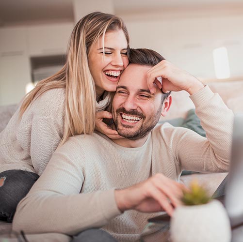 couple at home laughing on couch