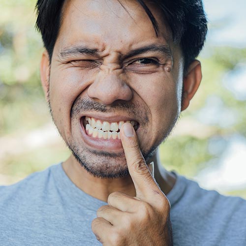 man with tooth pain in need of treatment for a root canal in Brampton