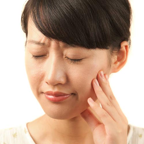 Woman with tooth pain requires immediate attention of an emergency dentist in Brampton